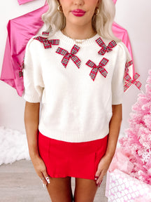 Ivory plaid Put a Bow On It sweater with red bows.
