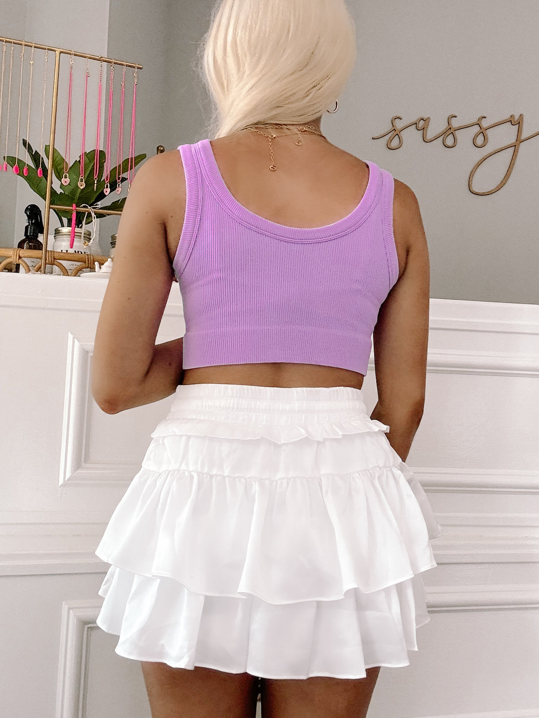 Lilac ribbed tank top and white ruffled mini skirt, styled for a casual look.
