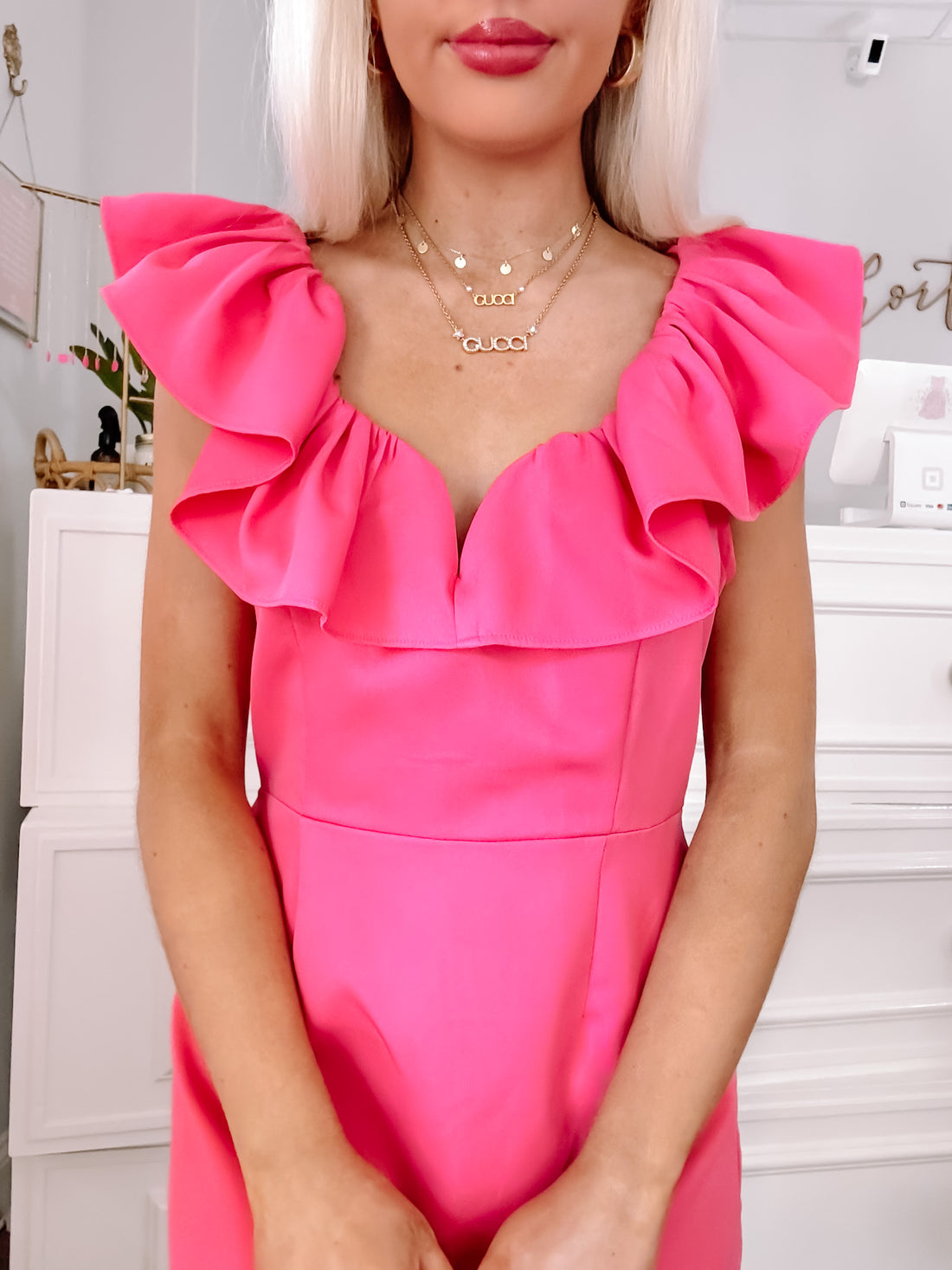 Hot pink dress with ruffled shoulders, shown on a model.
