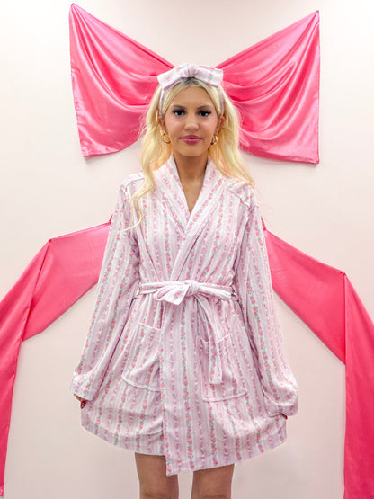 Rose Floral Robe from Sassy Shortcake - Girl wearing a pink striped robe with a decorative headband in front of pink bow.