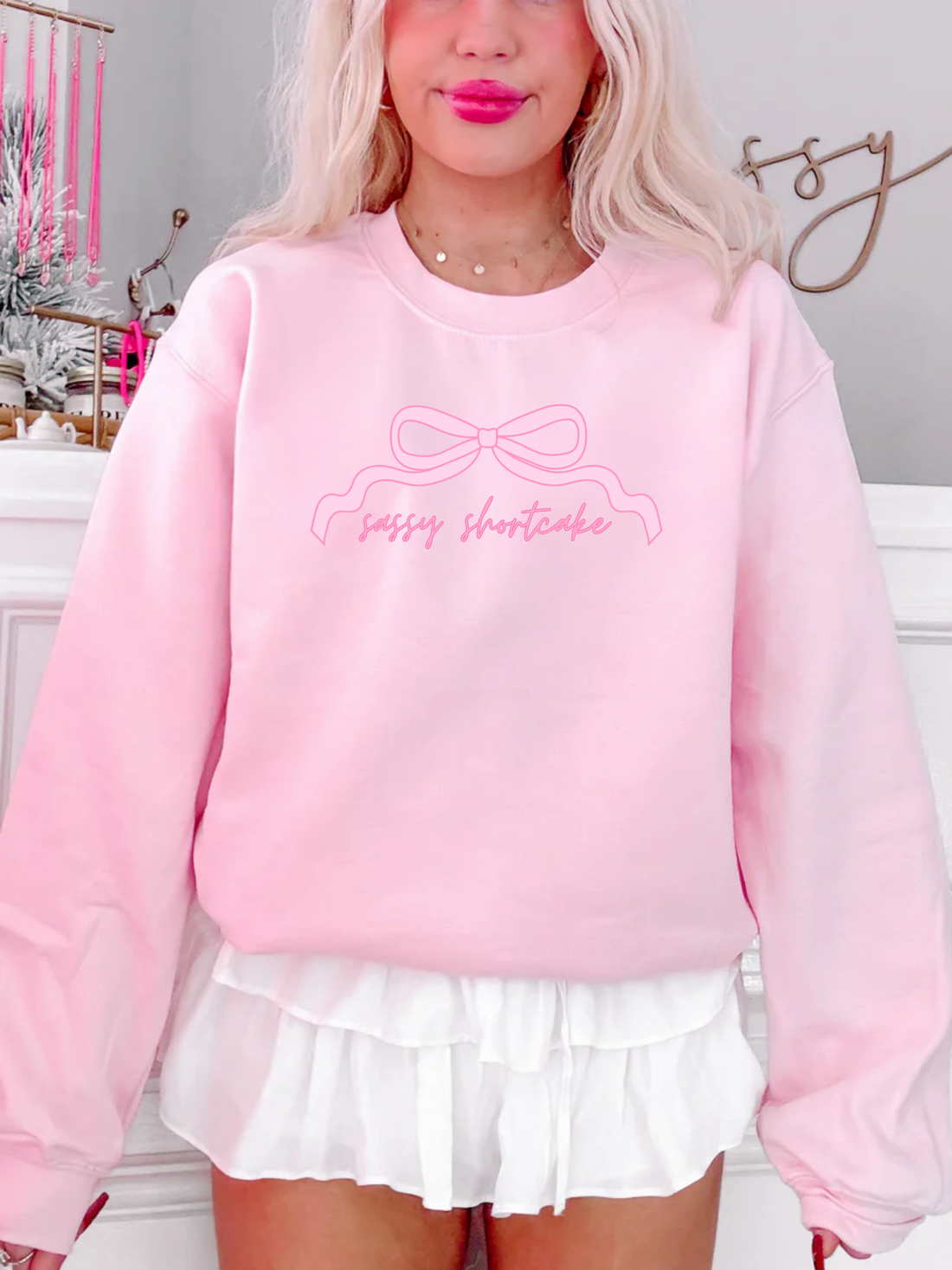 Close-up of pink Sassy Bow Crewneck showing bow graphic and Sassy Shortcake logo on the chest.
