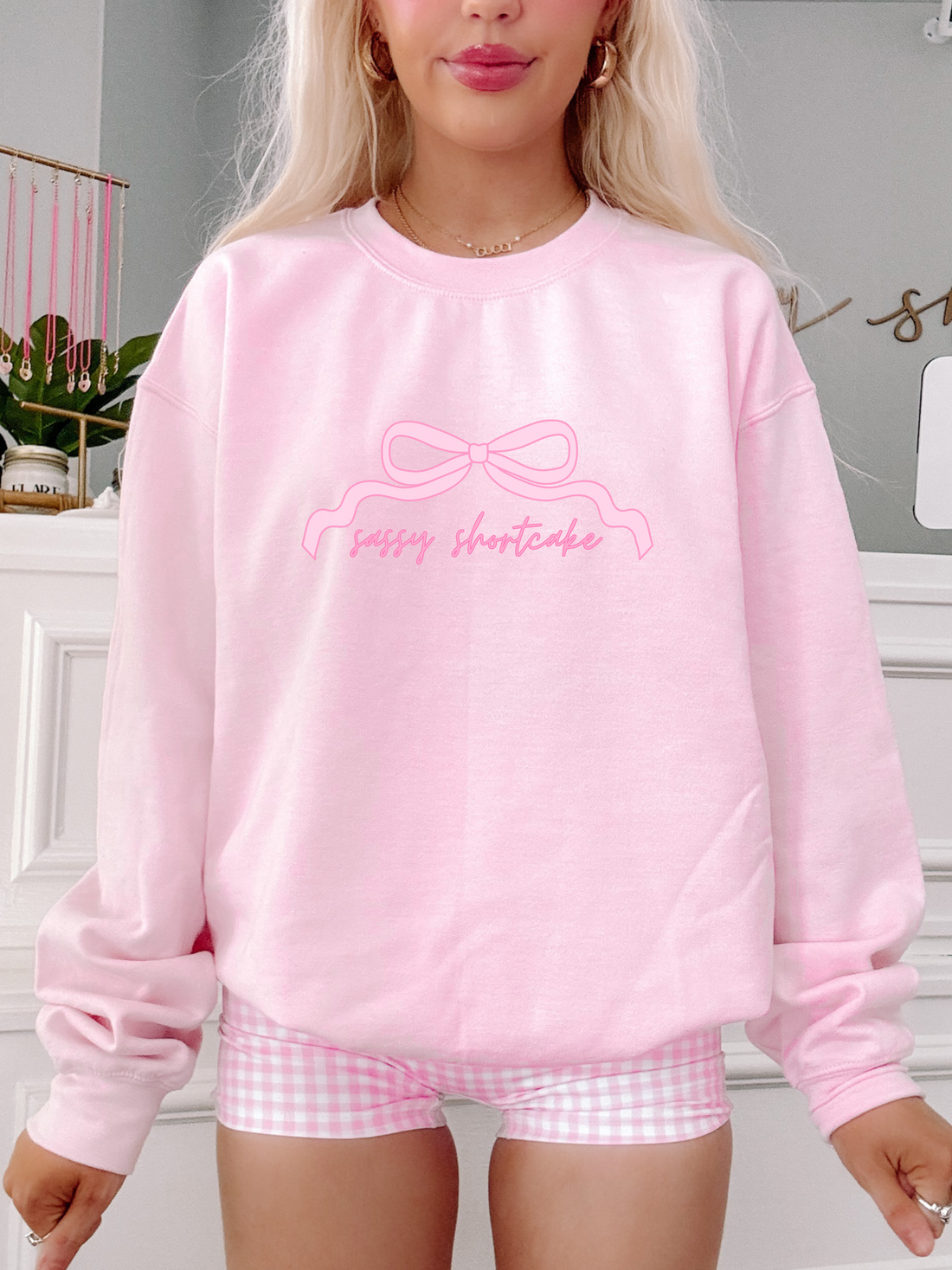 Model wearing light pink Sassy Bow Crewneck sweatshirt with script sassy shortcake logo – Sassy Shortcake merch