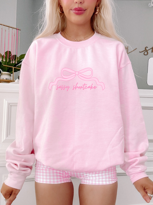 Model wearing light pink Sassy Bow Crewneck sweatshirt with script sassy shortcake logo – Sassy Shortcake merch