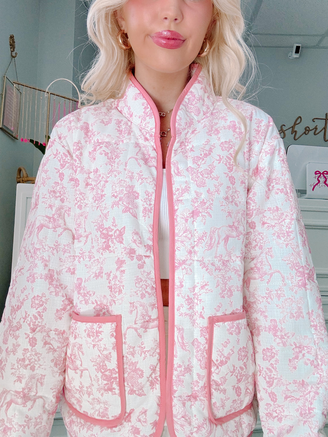 Person wearing a pink and white floral jacket indoors from Sassy Shortcake