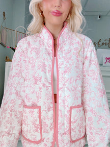 Person wearing a pink and white floral jacket indoors from Sassy Shortcake
