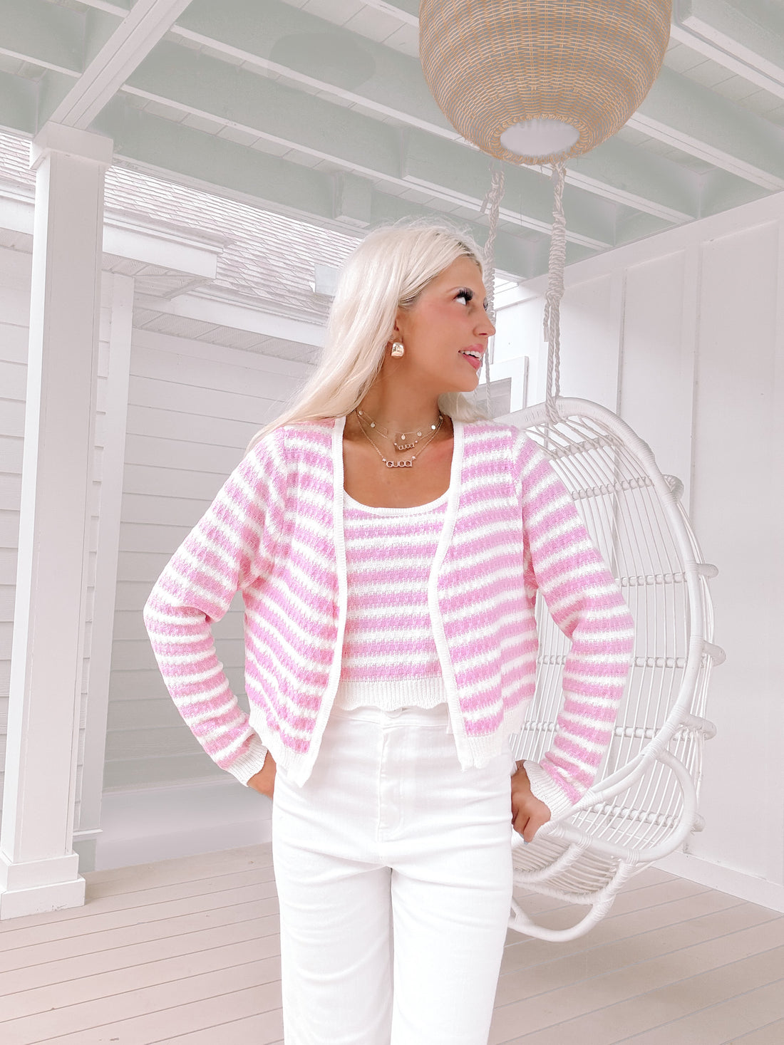 Pink and white striped knit cardigan and tank top set, modeled outdoors on a porch.
