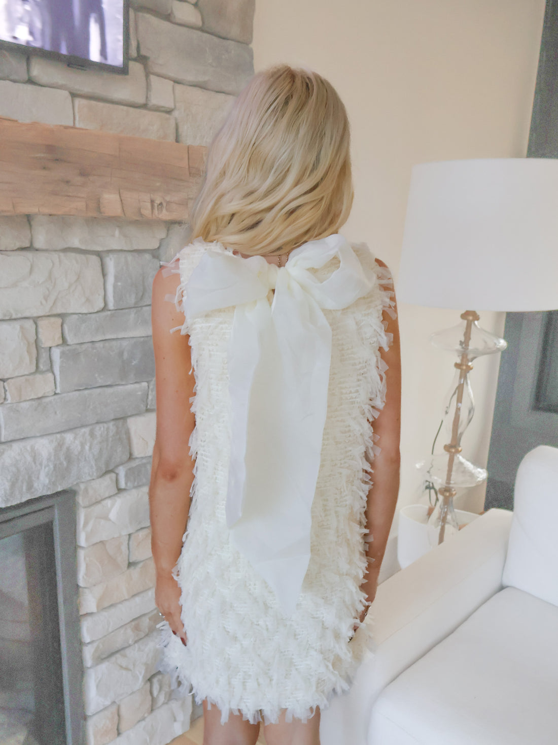 Back View of Sassy Shortcake Snowfall Dress on model, white textured mini dress with sleeveless silhouette and winter party style.