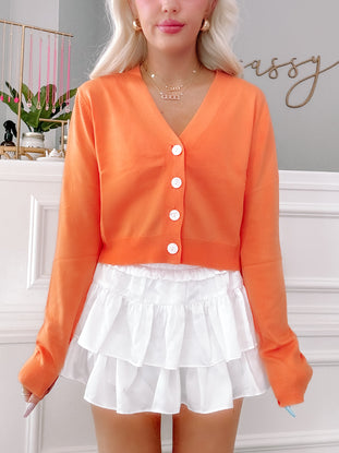 Orange Spencer cardigan with white buttons
