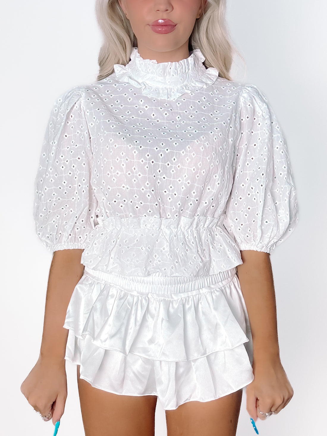 White eyelet Sutton top with puff sleeves and ruffled satin shorts.
