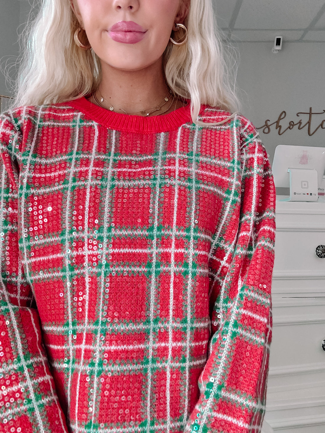 Red and green sequined plaid sweater, close-up view.
