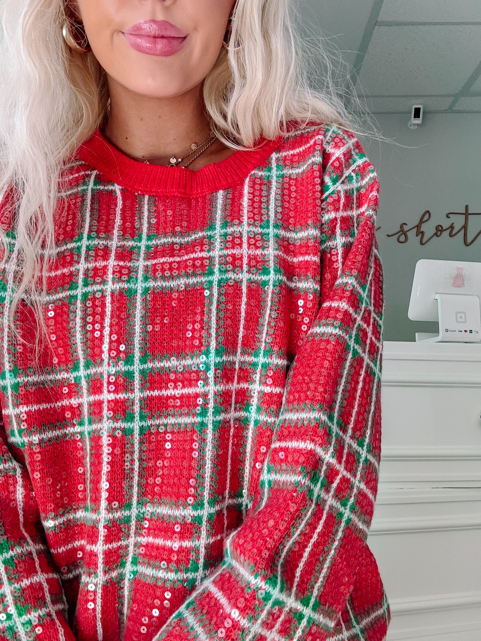 Red plaid sequin sweater – perfect for holiday gatherings. Available at Sassy Shortcake