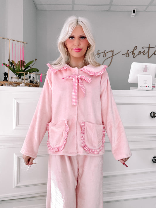 Pink plush pajama set with gingham trim, modeled in Sassy Shortcake