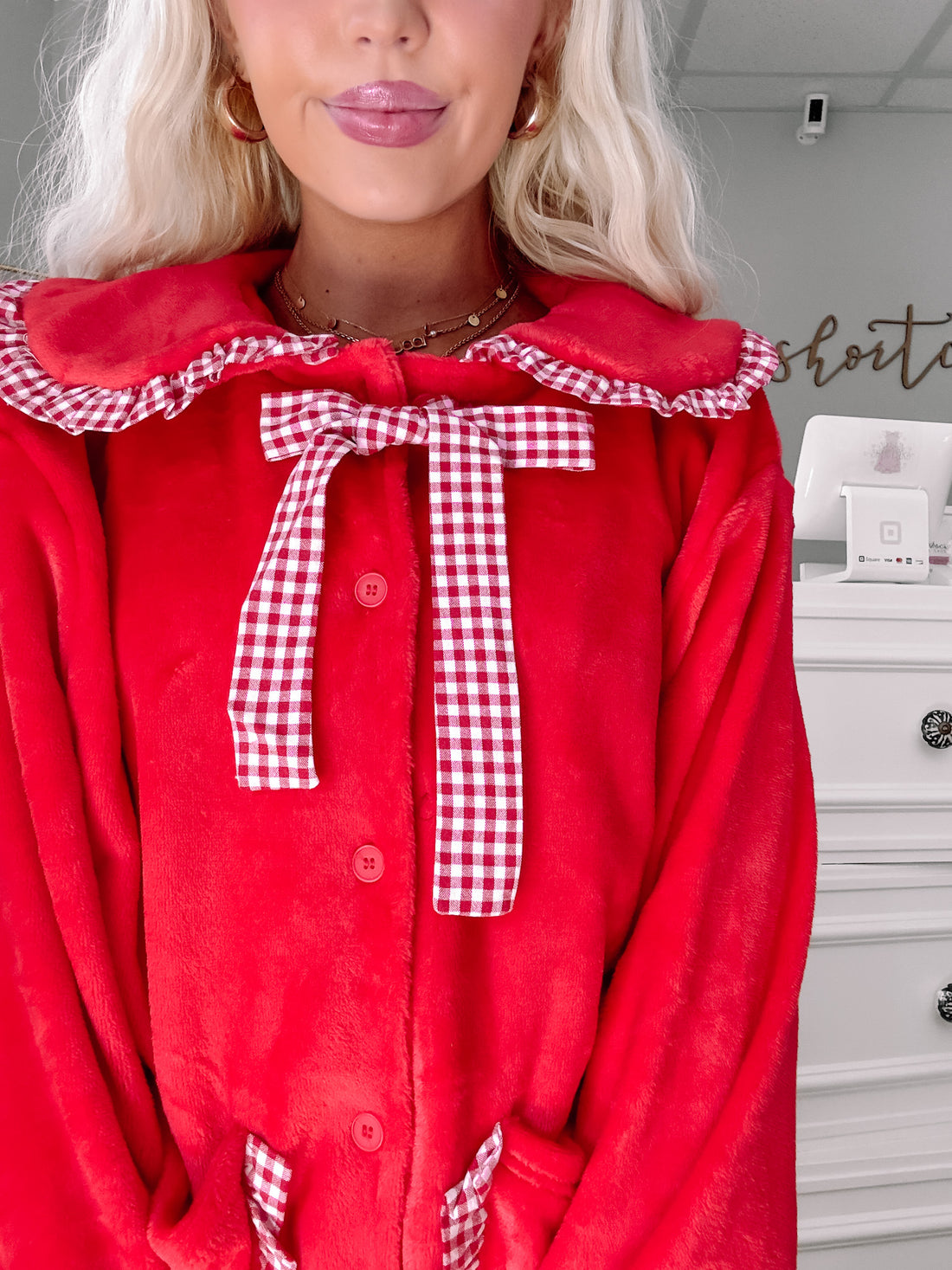 Red fleece pajama set with gingham trim and bow detail.
