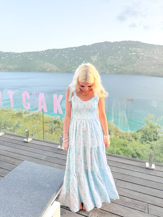 Sassy Shortcake Sweet Pea blue floral maxi with tie shoulders and flowing tiers on oceanfront deck.