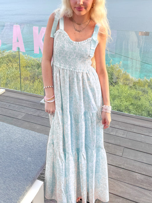 Sassy Shortcake Sweet Pea blue floral maxi dress on balcony — smocked bodice, tie-shoulder bows, tiered skirt