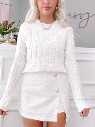 White Posh Pearl cable knit sweater with pearl detailing.
