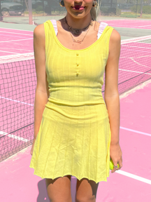 Yellow Twirl & Train tennis dress from Sassy Shortcake on pink tennis court
