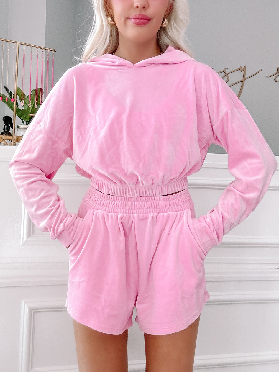 Pink velour hoodie and shorts lounge set; soft, comfortable fabric.
