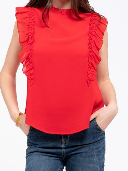 Red sleeveless blouse with ruffle trim, modeled over jeans.
