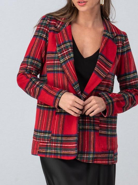 Red and green plaid blazer, buttoned, worn over a black top.
