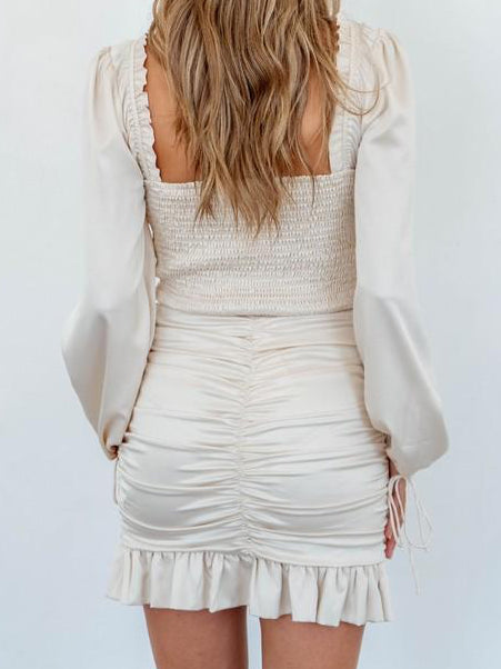 Cream mini skirt with ruched back and frilly hem.
