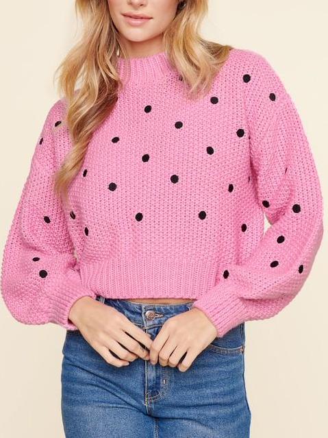 Pink knit sweater with black polka dots, shown on model.

