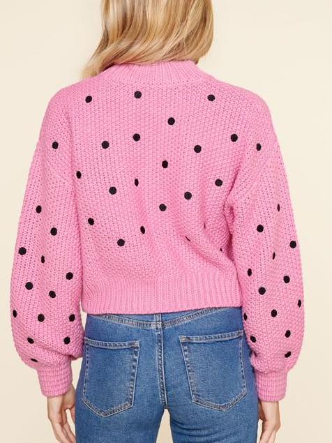 Pink knit sweater with black polka dots, balloon sleeves, and cropped length.
