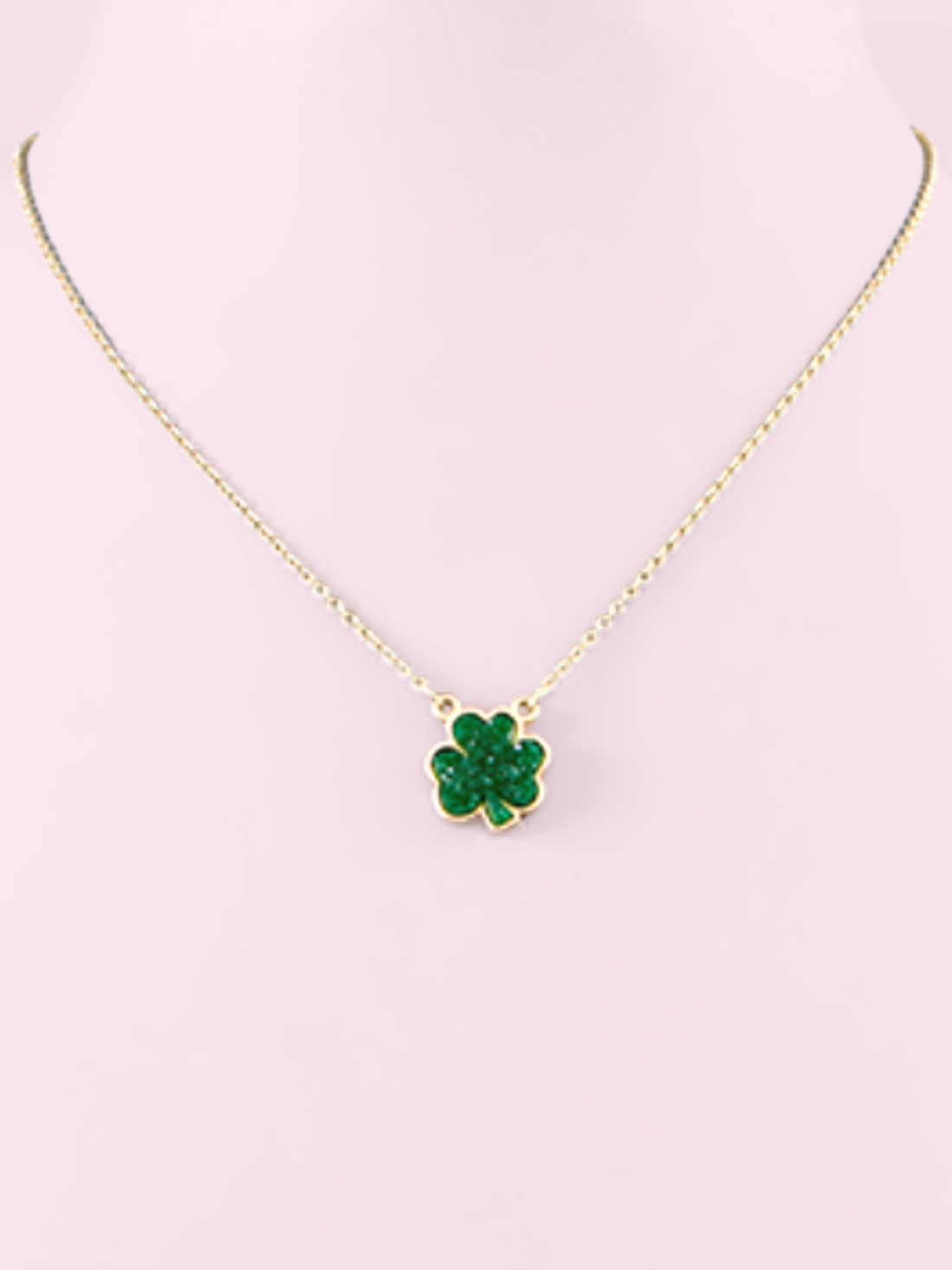 Gold chain necklace with sparkling green shamrock pendant.
