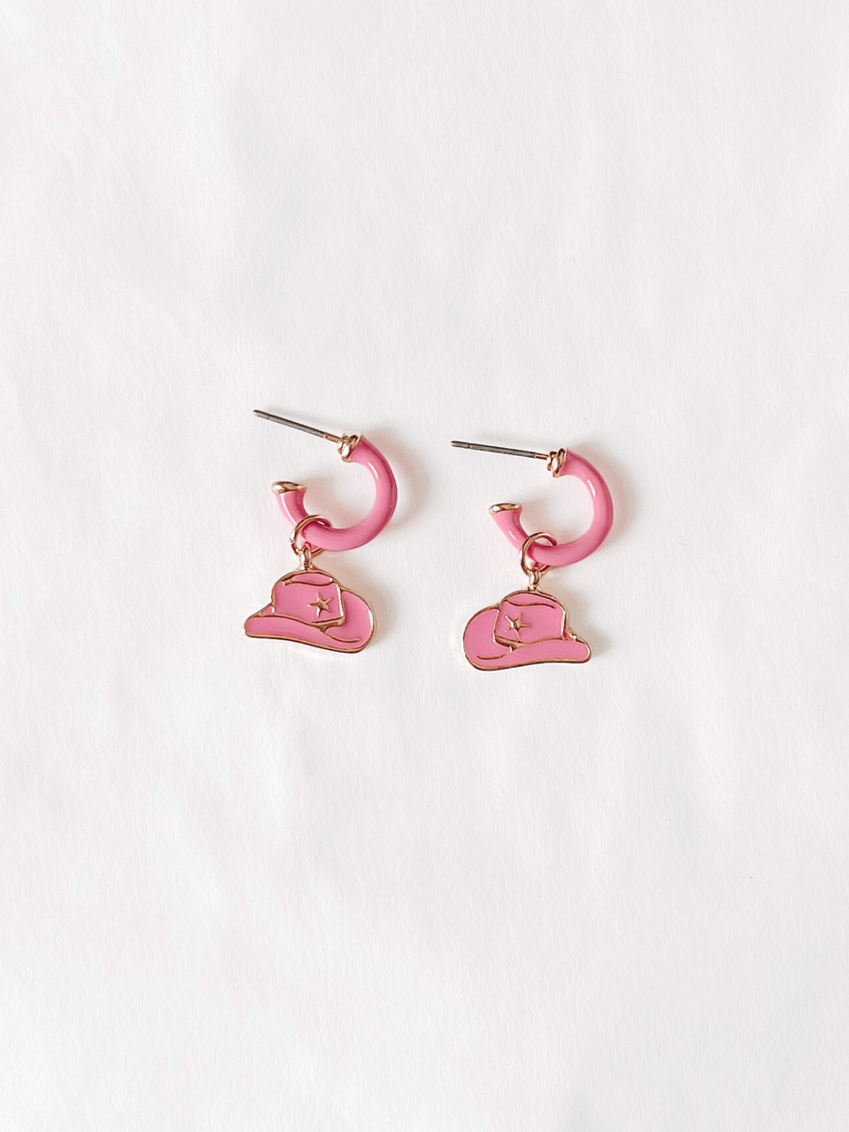 Pink cowgirl hat earrings:  Charming pink enamel hoops with gold-tone cowboy hat charms.
