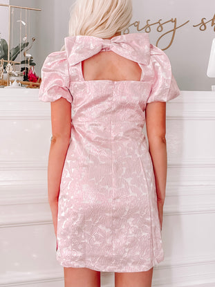 Pink Let it Bow Dress:  Elegant puff-sleeve mini dress with unique back bow detail.
