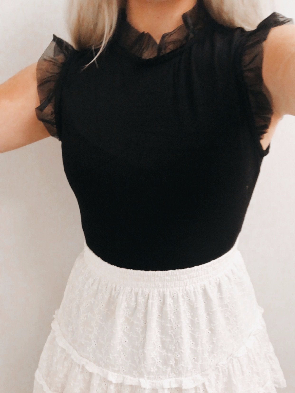 Black Ruffle Rhythm Top; sheer ruffle sleeves, fitted silhouette.
