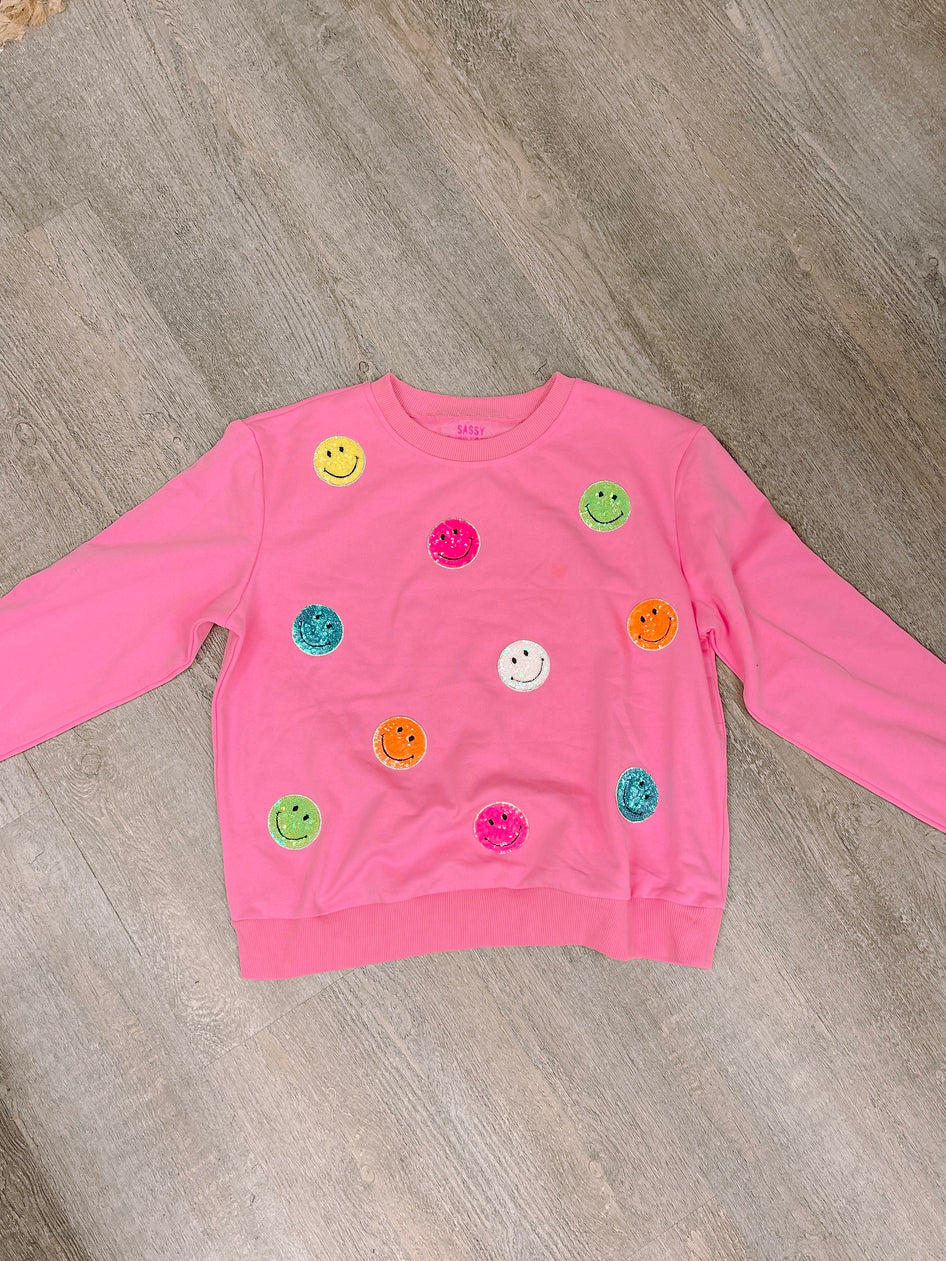 Pink Sassy Super Smiles crewneck sweatshirt with colorful glitter smiley faces.
