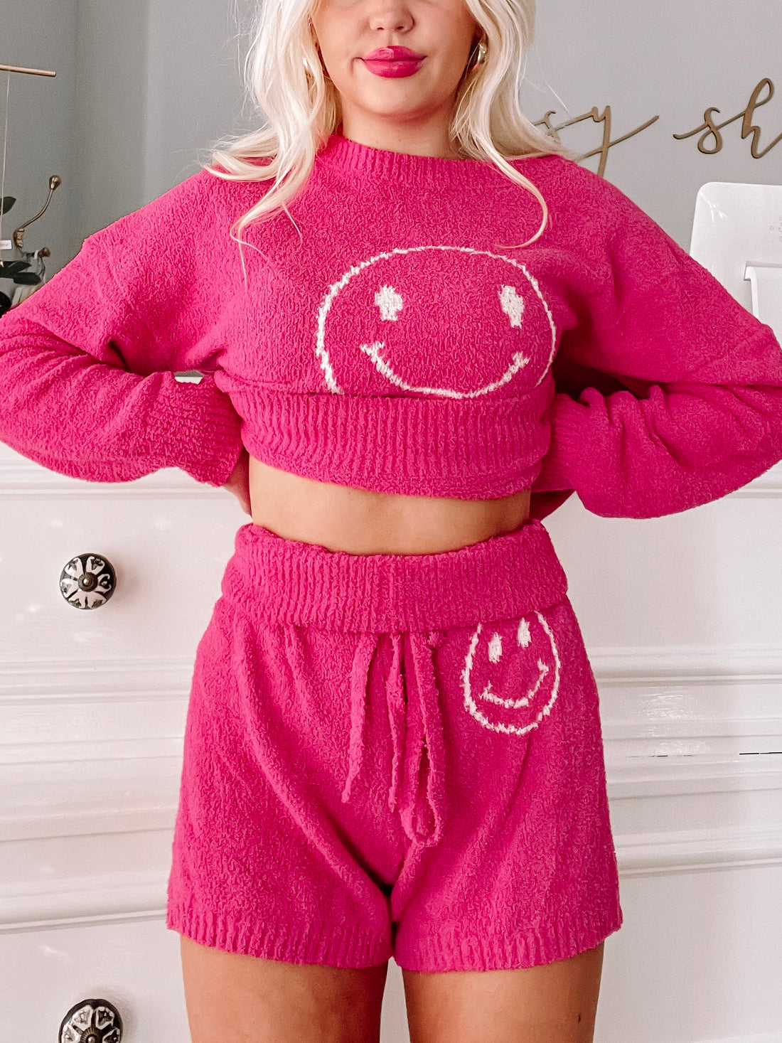 Hot pink fuzzy sweater and shorts lounge set; features embroidered smiley faces.
