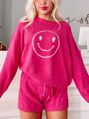 Fuzzy hot pink sweater and shorts set featuring a smiling face; cozy loungewear.
