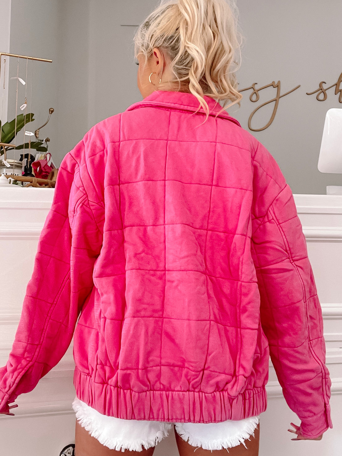 Hot pink quilted jacket, back view, showcasing the square stitching detail.
