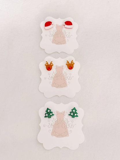 Miniature holiday-themed earrings; Santa hats, reindeer, and Christmas trees.
