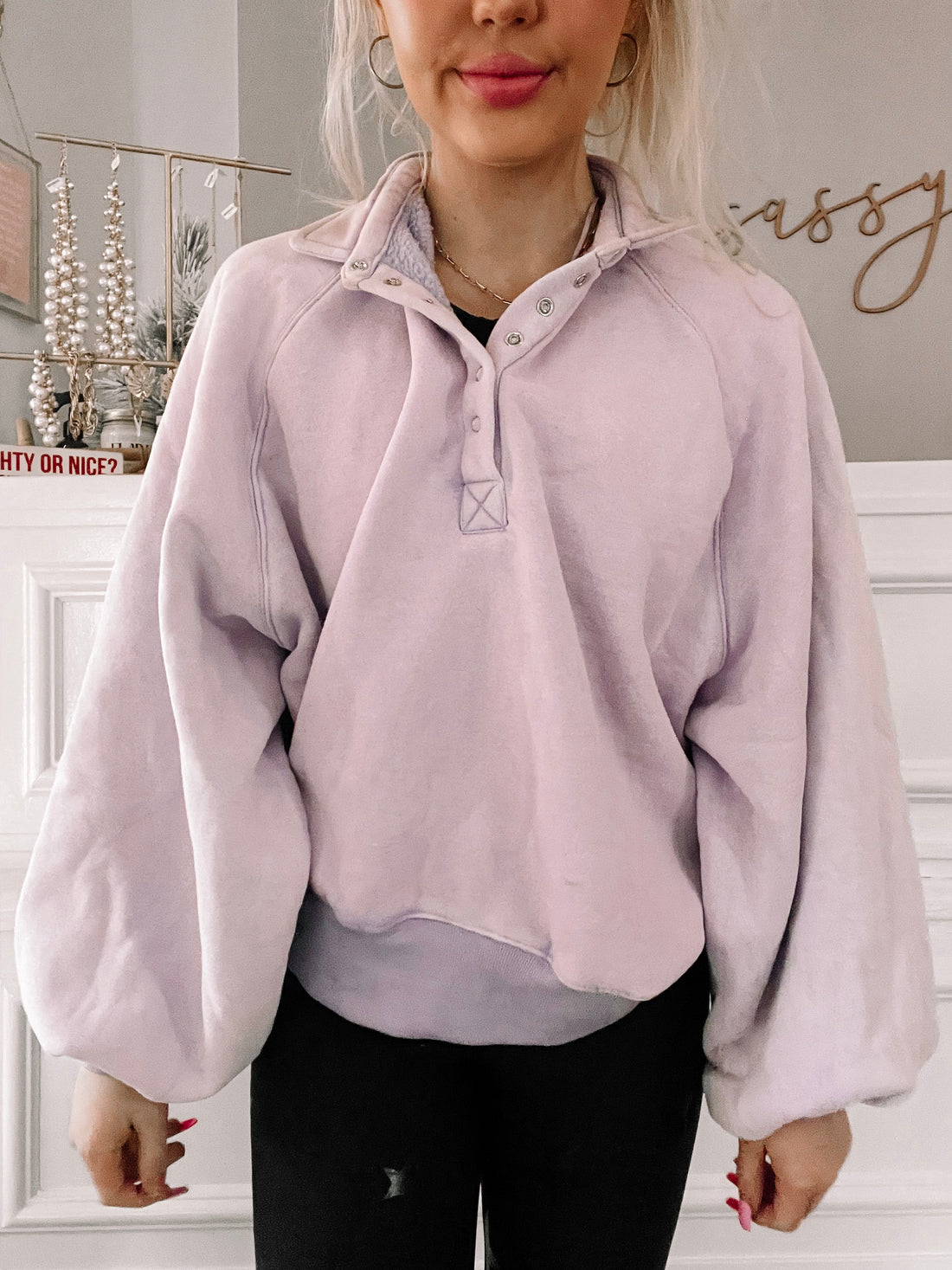 Lilac pullover with balloon sleeves and button placket, modeled against a neutral background.
