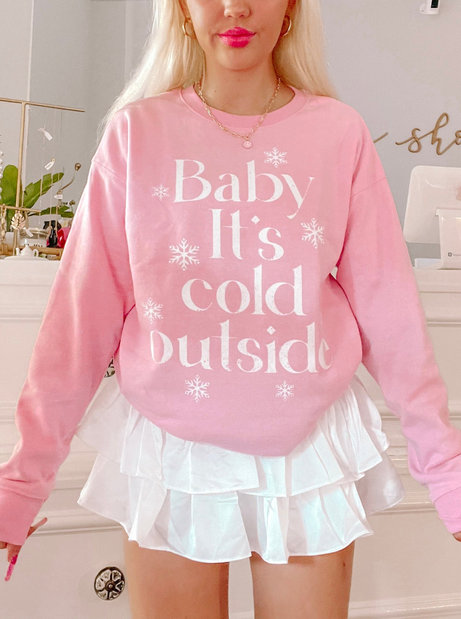 Pink "Baby It's Cold Outside" crewneck sweatshirt with snowflake accents
