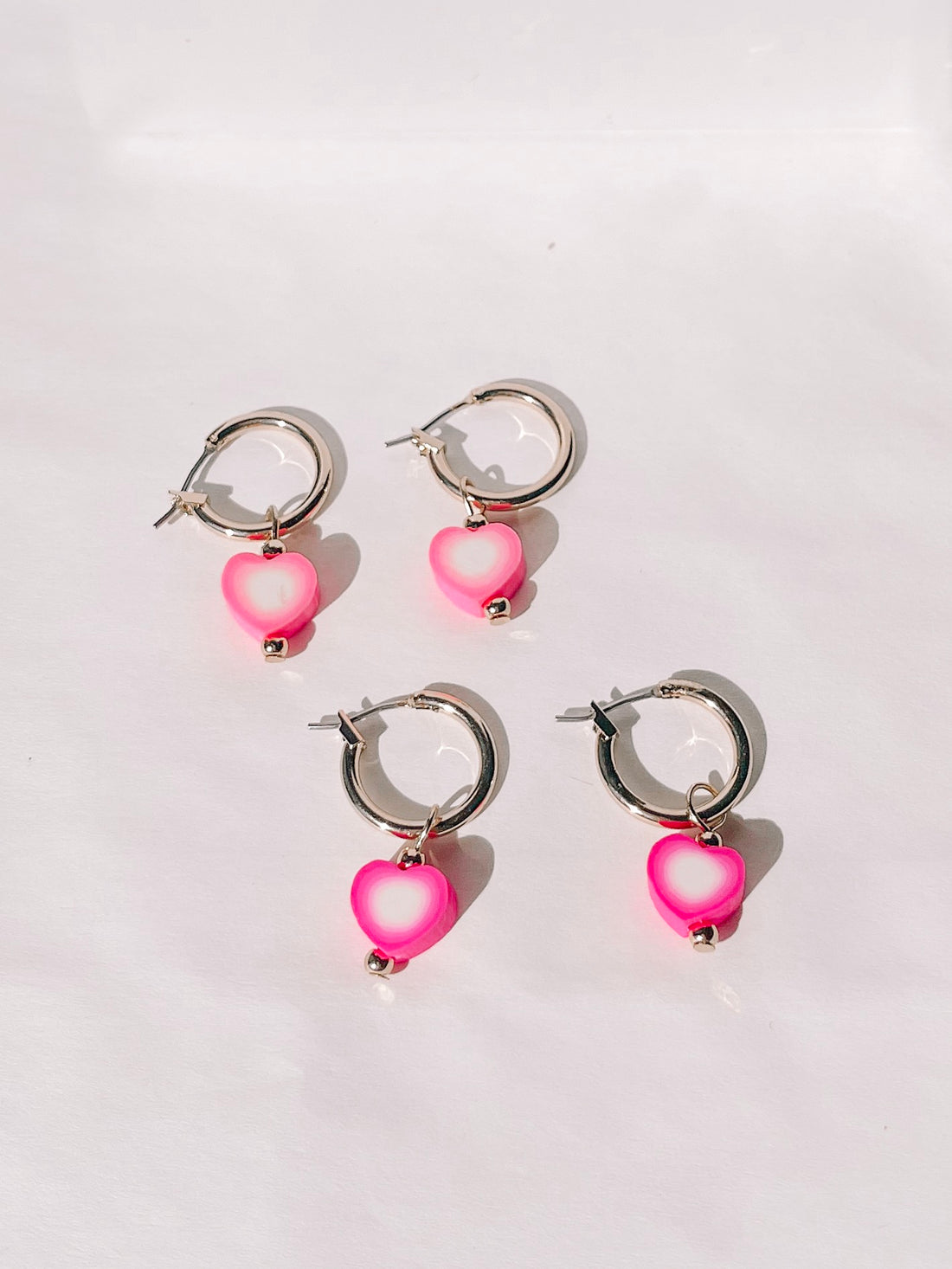 Pink and white heart charm gold hoop earrings
