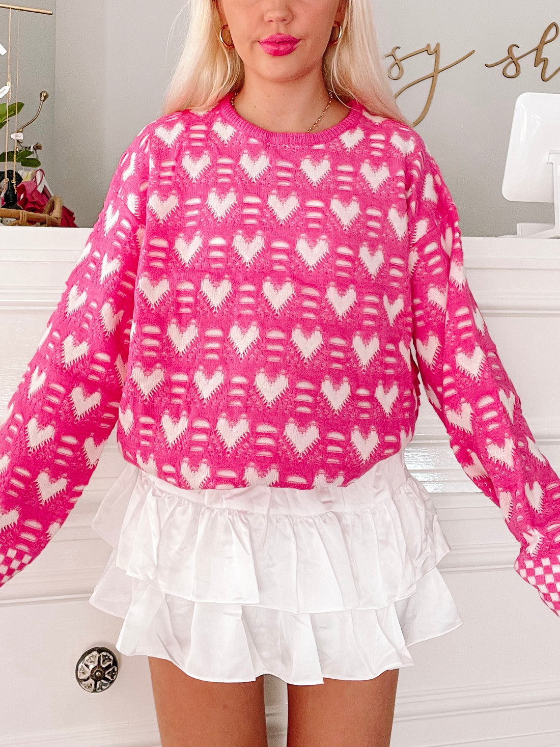 Pink sweater with white heart pattern

