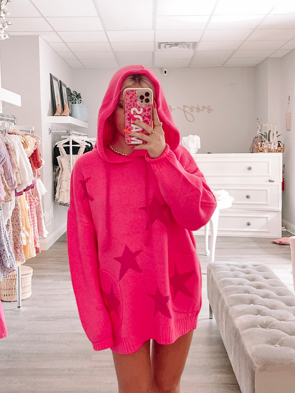 Hot pink star-print sweater; oversized fit, hooded neckline.
