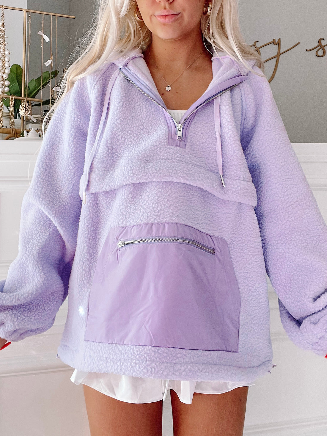 Lilac fleece pullover with contrasting purple nylon pocket detail.
