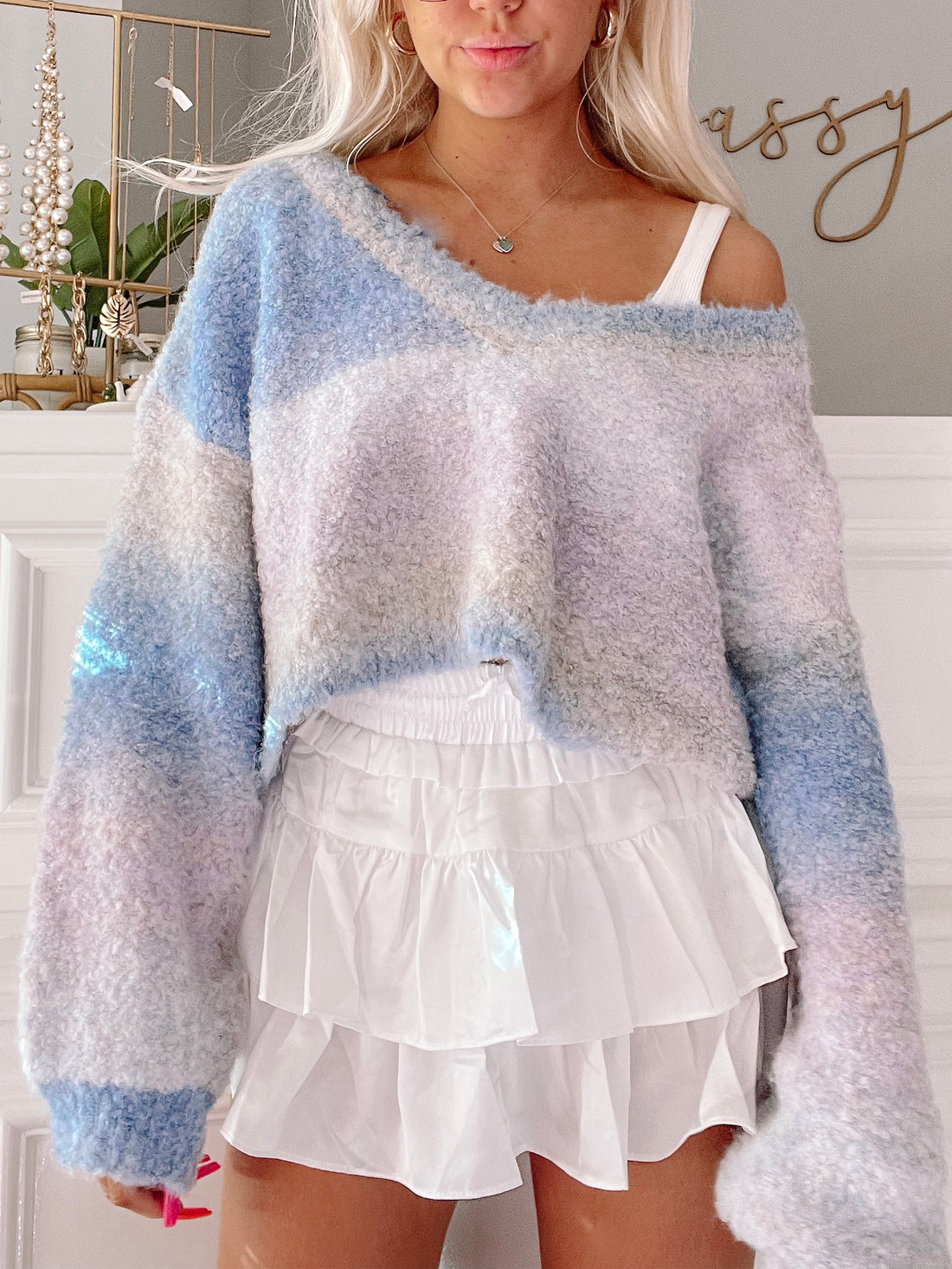 Fuzzy pastel ombre sweater with a relaxed fit, shown paired with a white ruffle skirt.
