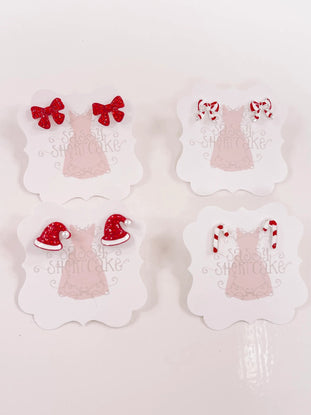 Red and white holiday-themed miniature earrings displayed on cards.

