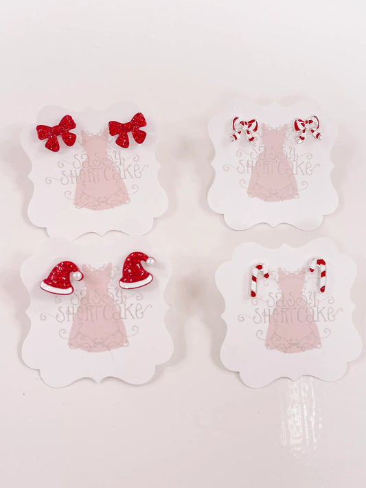 Red and white holiday-themed miniature earrings displayed on cards.
