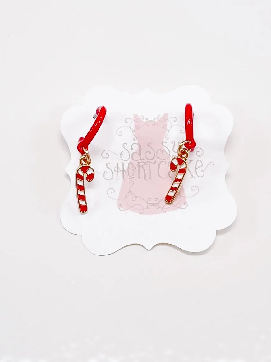 Red candy cane dangle earrings; gold hoops.
