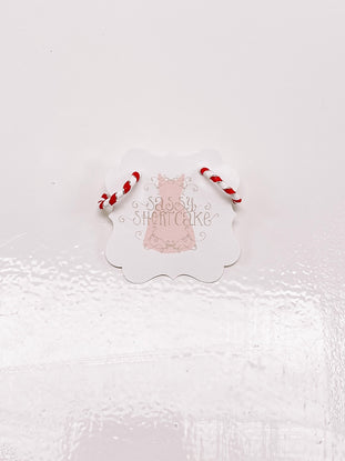 Candy cane-striped hoop earrings displayed on a product tag against a white background.
