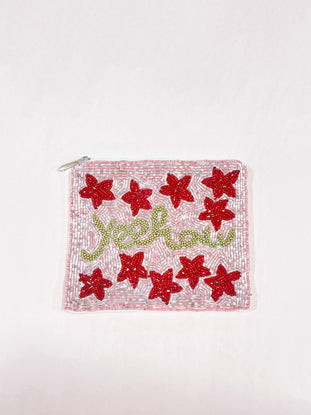 Pink beaded Yeehaw pouch with red flower accents and gold lettering.
