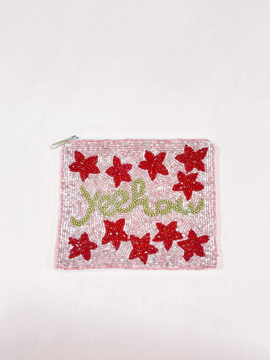 Pink beaded Yeehaw pouch with red flower accents and gold lettering.
