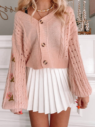 Pink Caplan Cardigan with cable knit, floral embroidery, and button closure.
